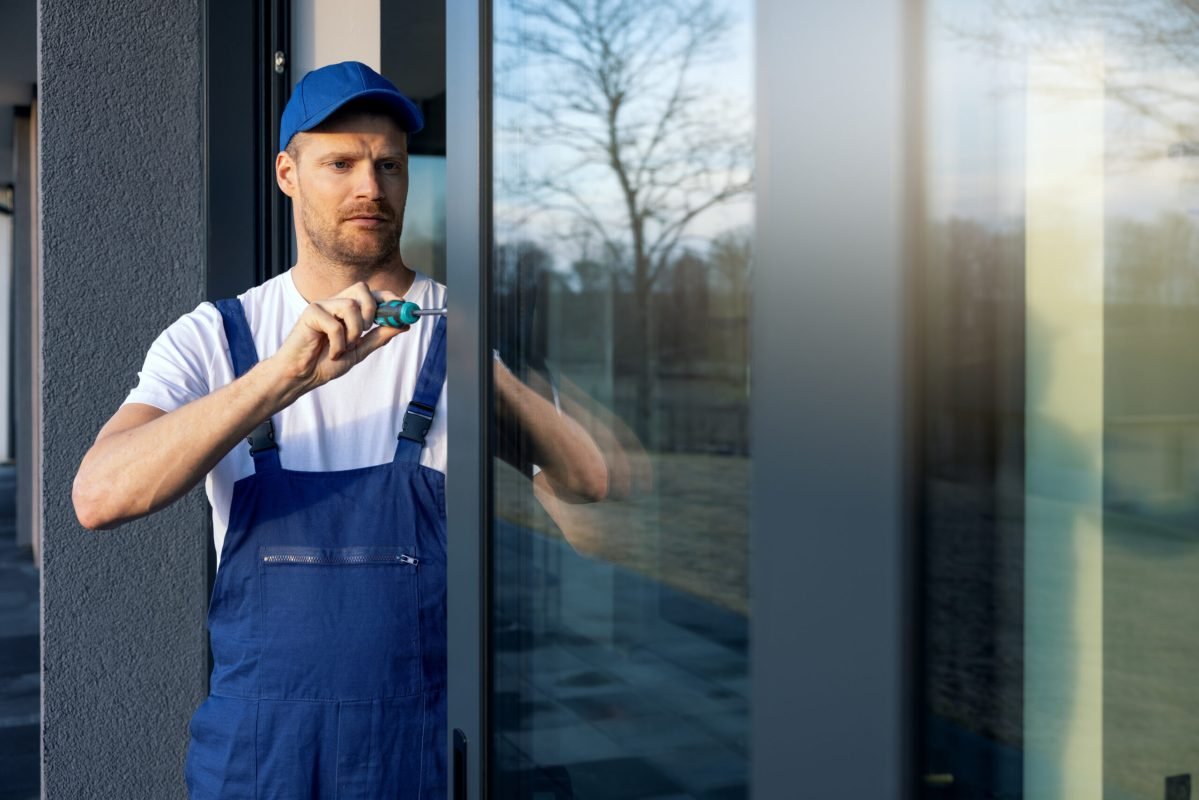 worker installing and adjusting aluminium frame sliding terrace doors